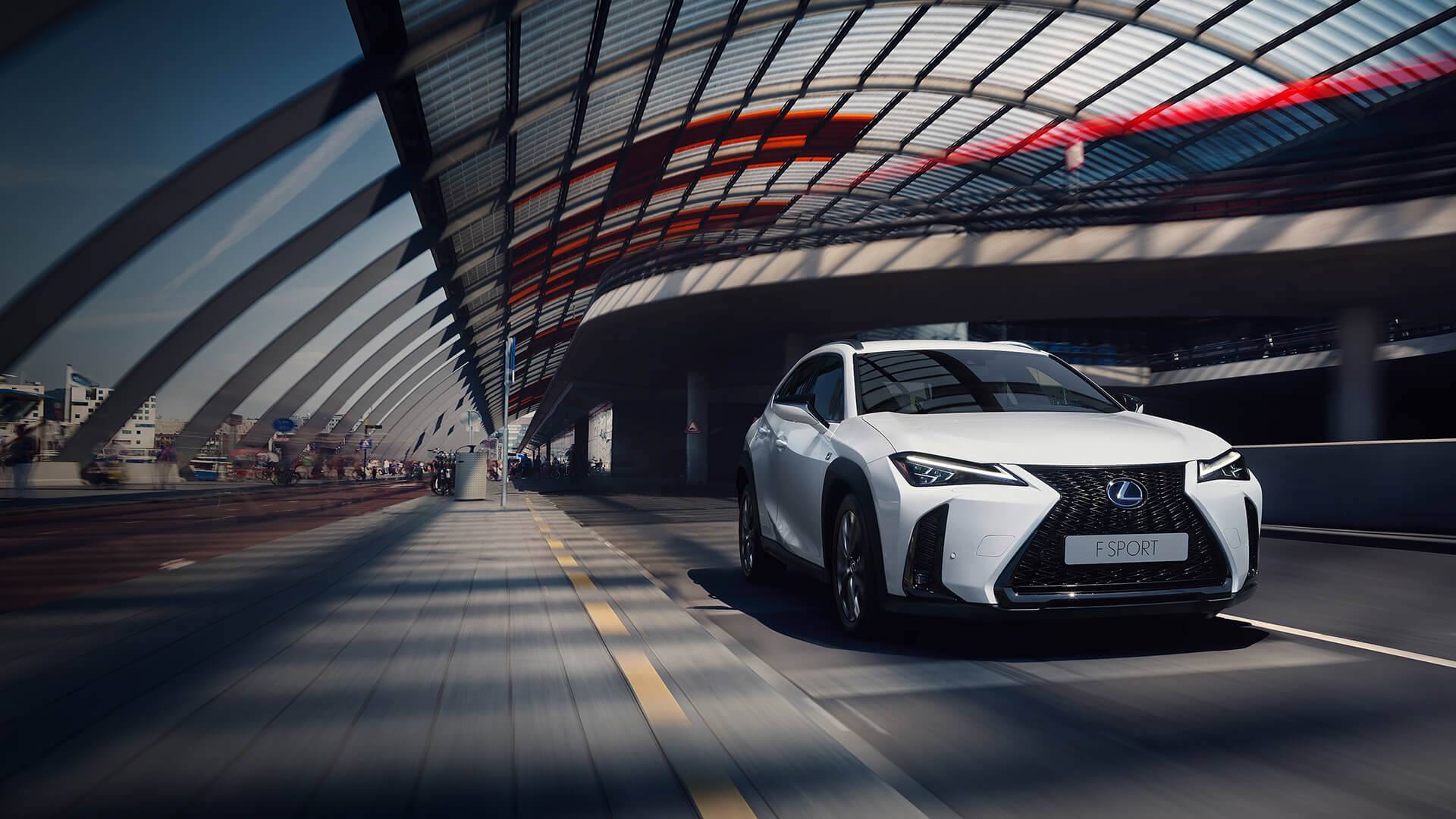 White Lexus UX being driven on the road.