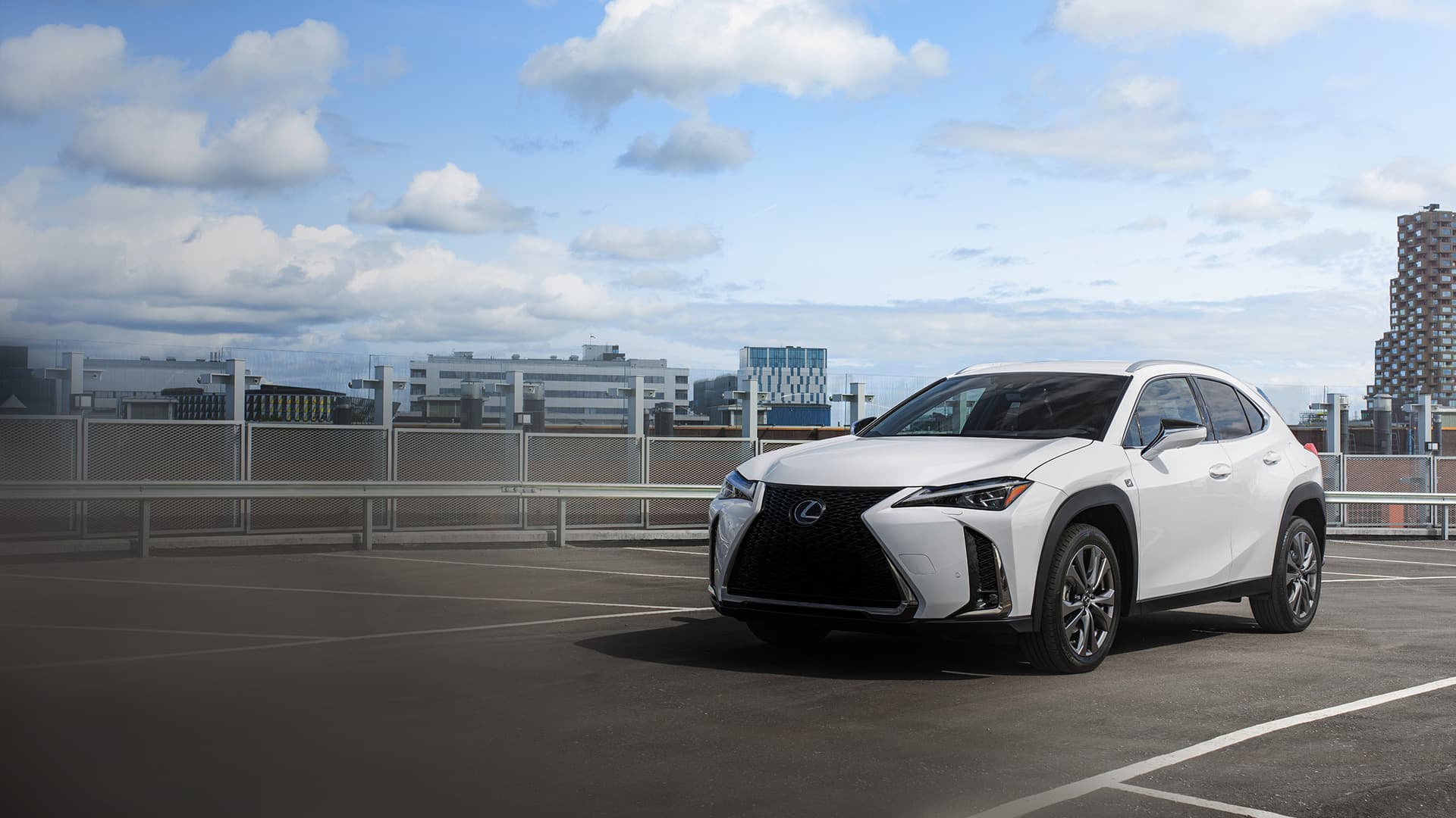 White Lexus UX driving along a mountain road.